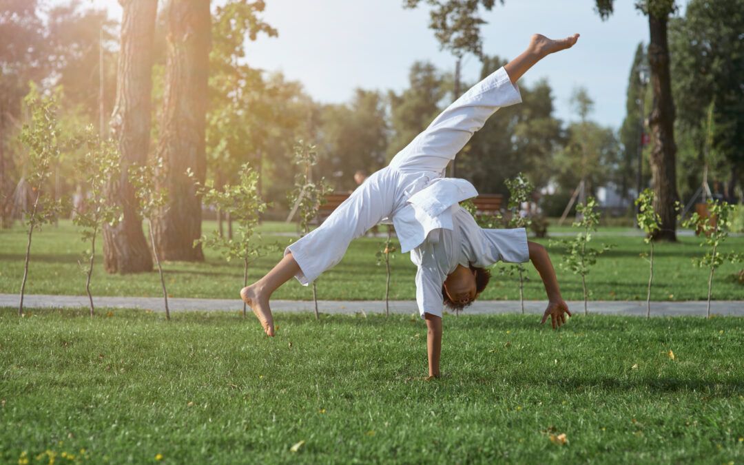 Niña practicando Capoeira y realizando una estrella